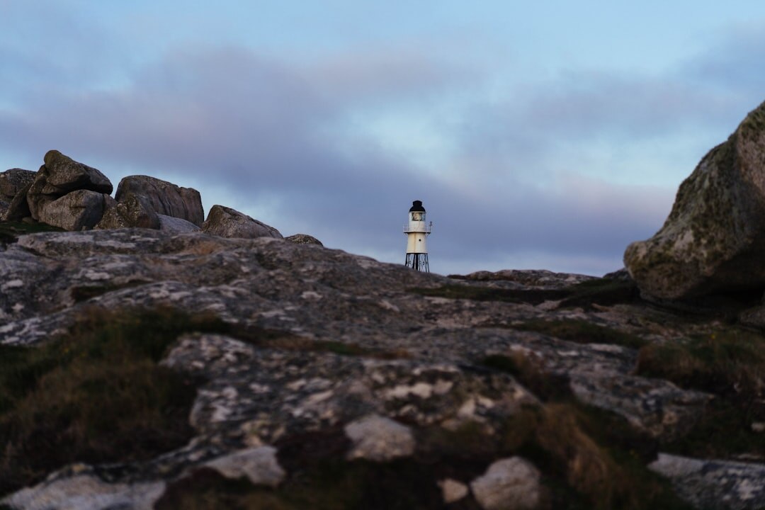 Lonely lighthouse on a rocky coast at dusk